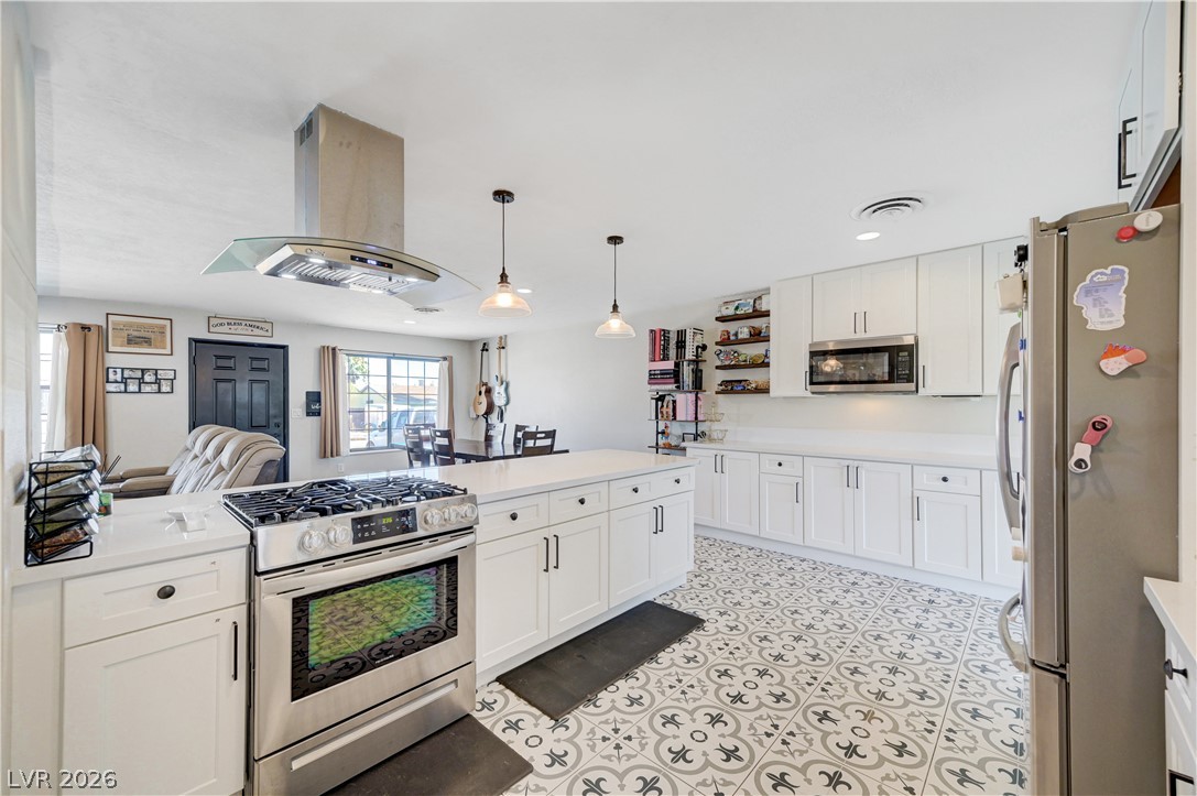 1331 Pinto Road Boulder City, NV 89005 - Photo 1 of 46 A well-appointed kitchen features a central island, ample cabinetry, and sleek stainless steel appliances, creating a vibrant culinary space.