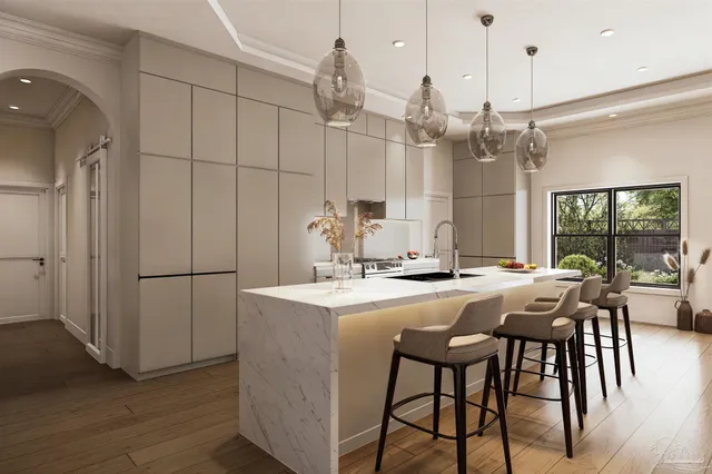 a kitchen with stainless steel appliances granite countertop a dining table chairs and white cabinets