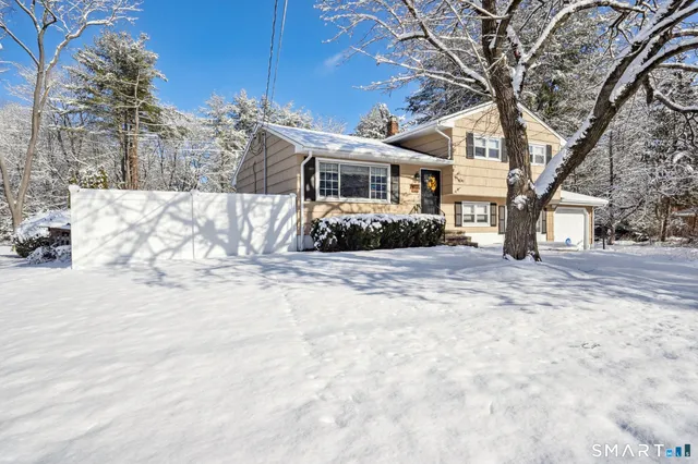 a front view of a house with a yard covered in snow