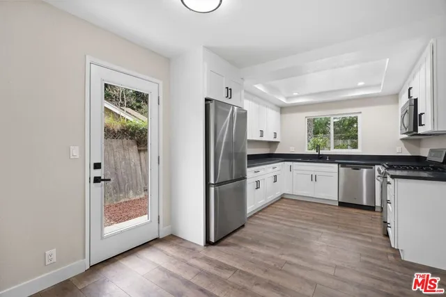 a kitchen with a refrigerator a sink and a stove top oven