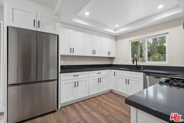 a kitchen with stainless steel appliances granite countertop a refrigerator sink and cabinets