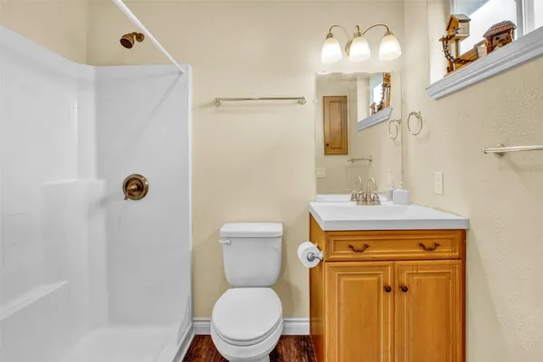 a bathroom with a toilet sink vanity and mirror