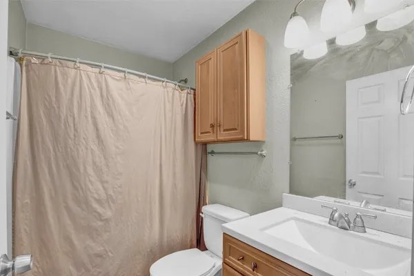 a bathroom with a sink a toilet and shower curtain
