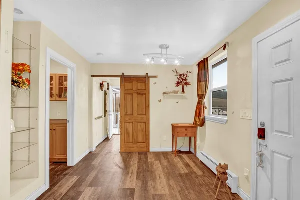 a view of a hallway with wooden floor and staircase