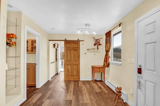 a view of a hallway with wooden floor and staircase