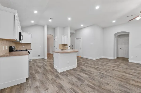 a view of kitchen with granite countertop cabinets and wooden floor