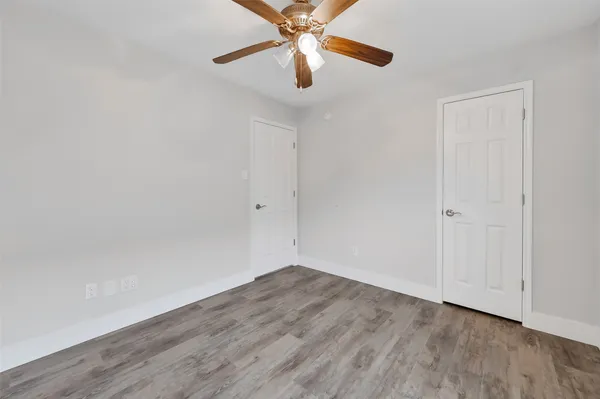 a view of a room with wooden floor and a ceiling fan