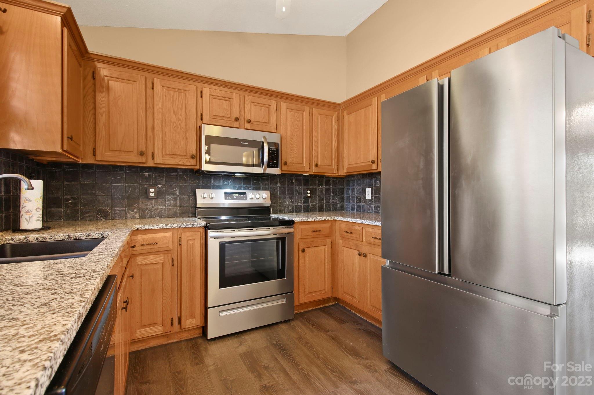 4863 Water Wheel Drive Conover, NC 28613 - Photo 10 of 32 a kitchen with granite countertop a refrigerator stove and microwave