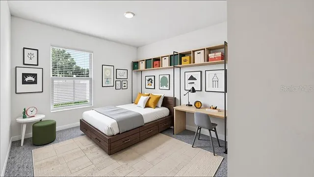 a bedroom with a bed a standing fan and a window