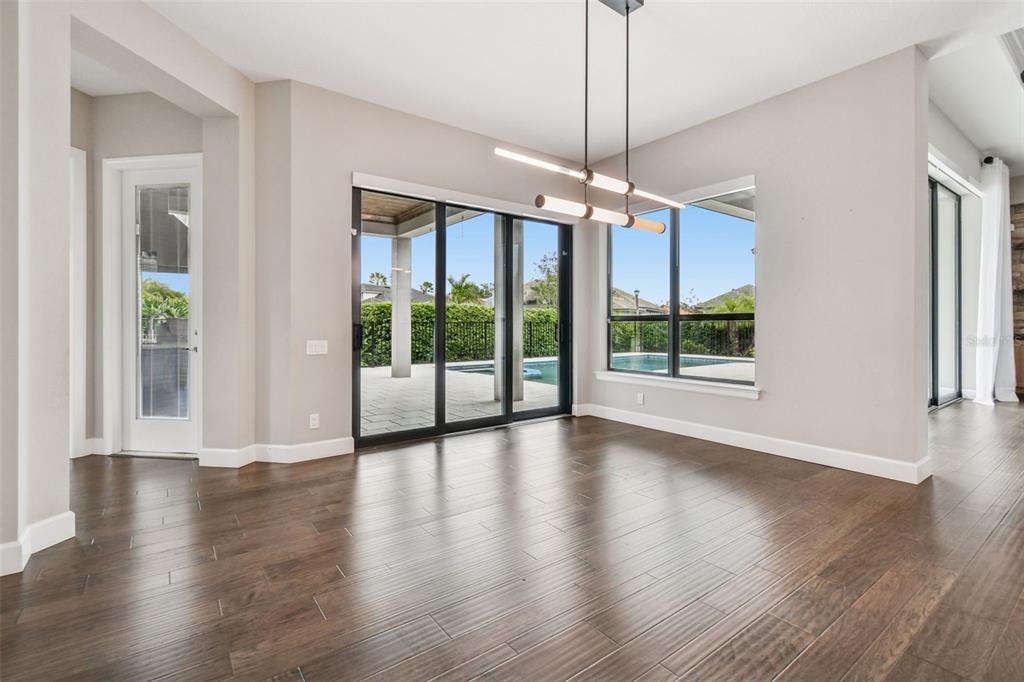 10605 Sabella Drive Trinity, FL 34655 - Photo 24 of 77 a view of an empty room with wooden floor fridge and a chandelier