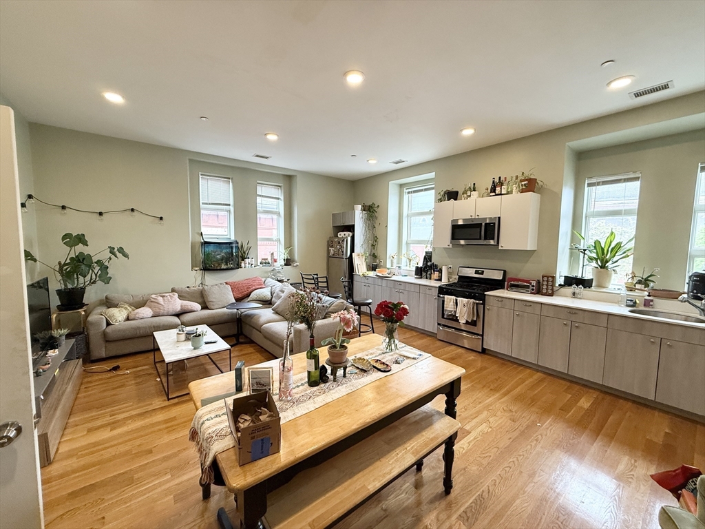 409 Dudley Street, Unit 4 Boston, MA 02119 - Photo 2 of 10 a living room with fireplace furniture and a wooden floor
