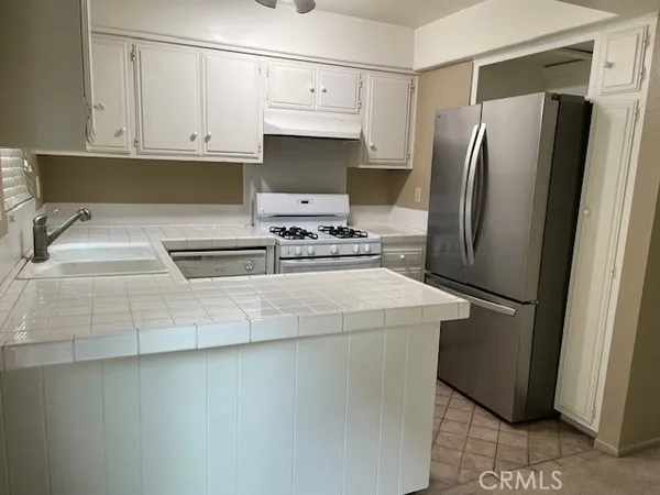 a kitchen with stainless steel appliances a refrigerator sink and cabinets