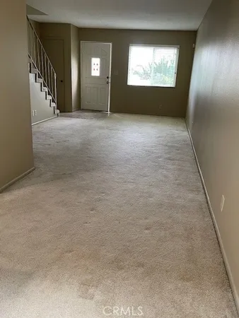 a view of an empty room and window in back of house