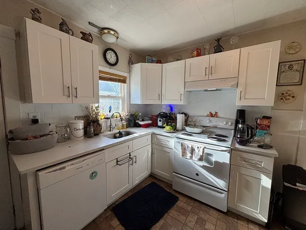 a kitchen with cabinets appliances a sink and a window