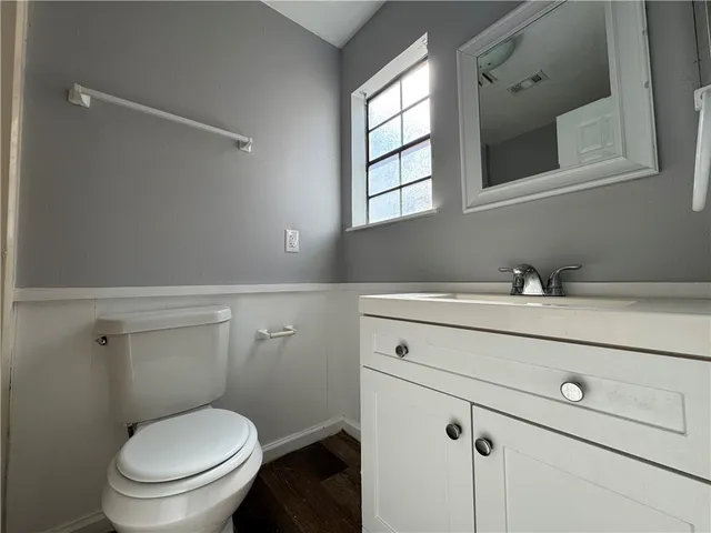 a bathroom with a toilet sink and mirror