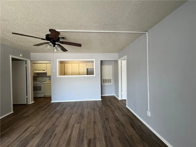 a view of empty room with wooden floor and window