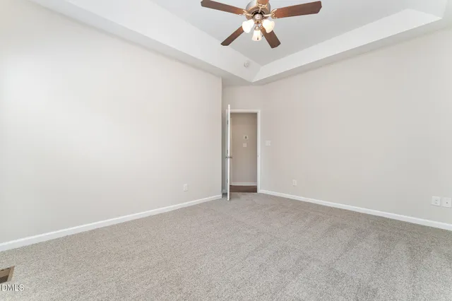 an empty room with a fan and a window
