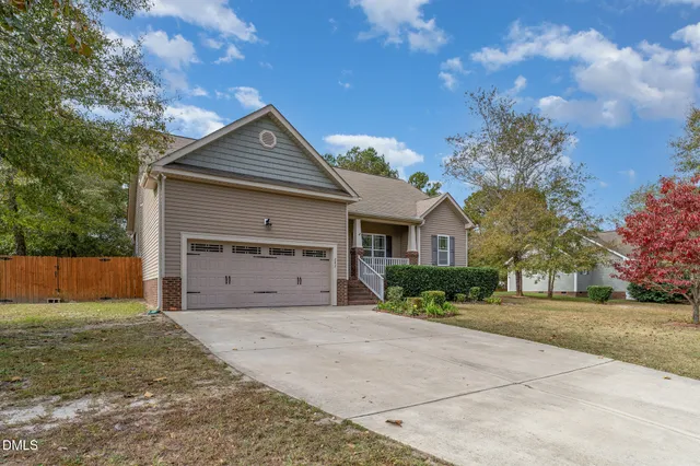 a front view of house with yard and trees in the background