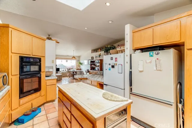 a kitchen with a sink a counter top space cabinets stainless steel appliances and a large window