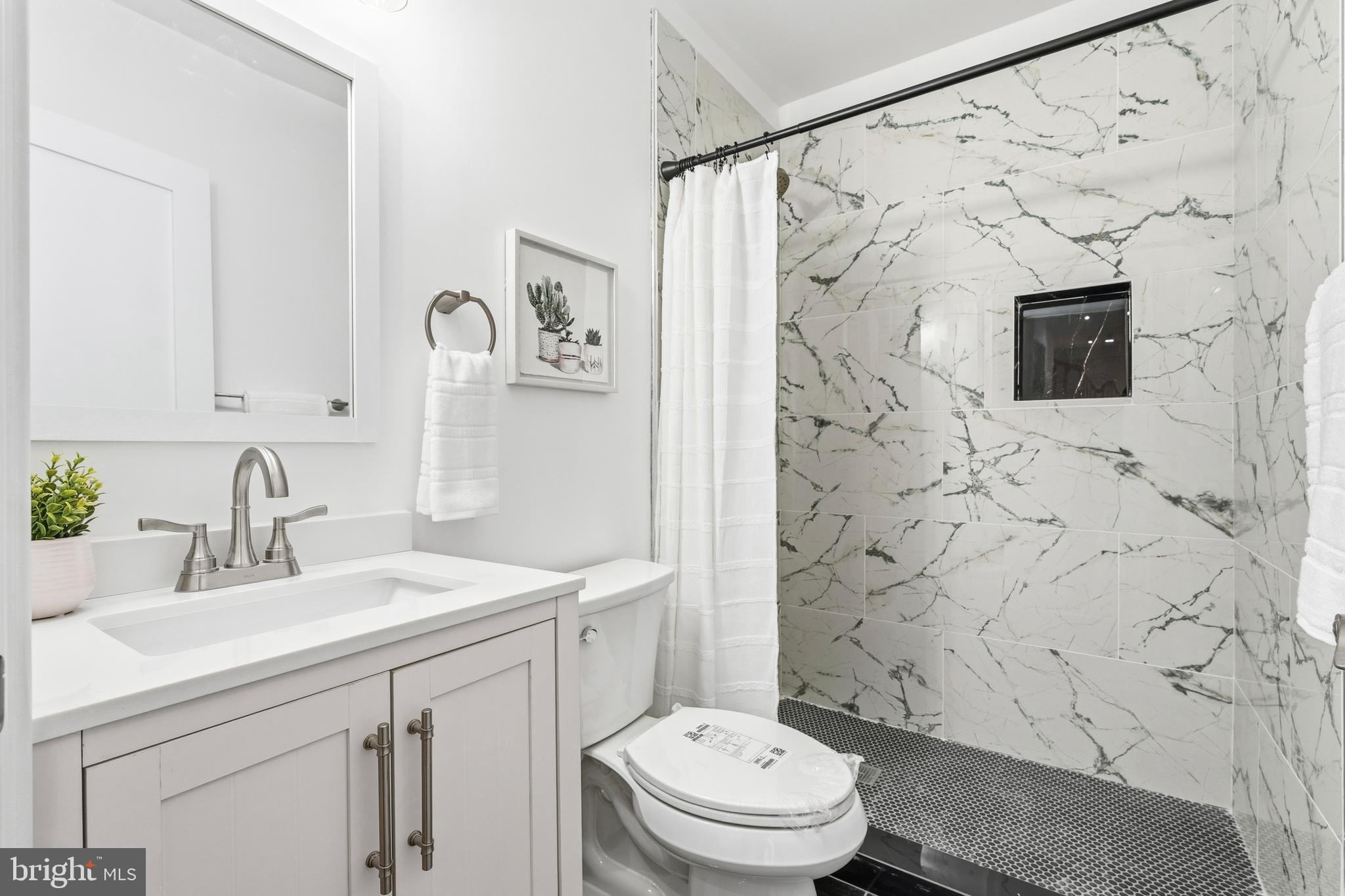 6218 Suitland Road Suitland, MD 20746 - Photo 17 of 52 a bathroom with a sink toilet a mirror a vanity and shower