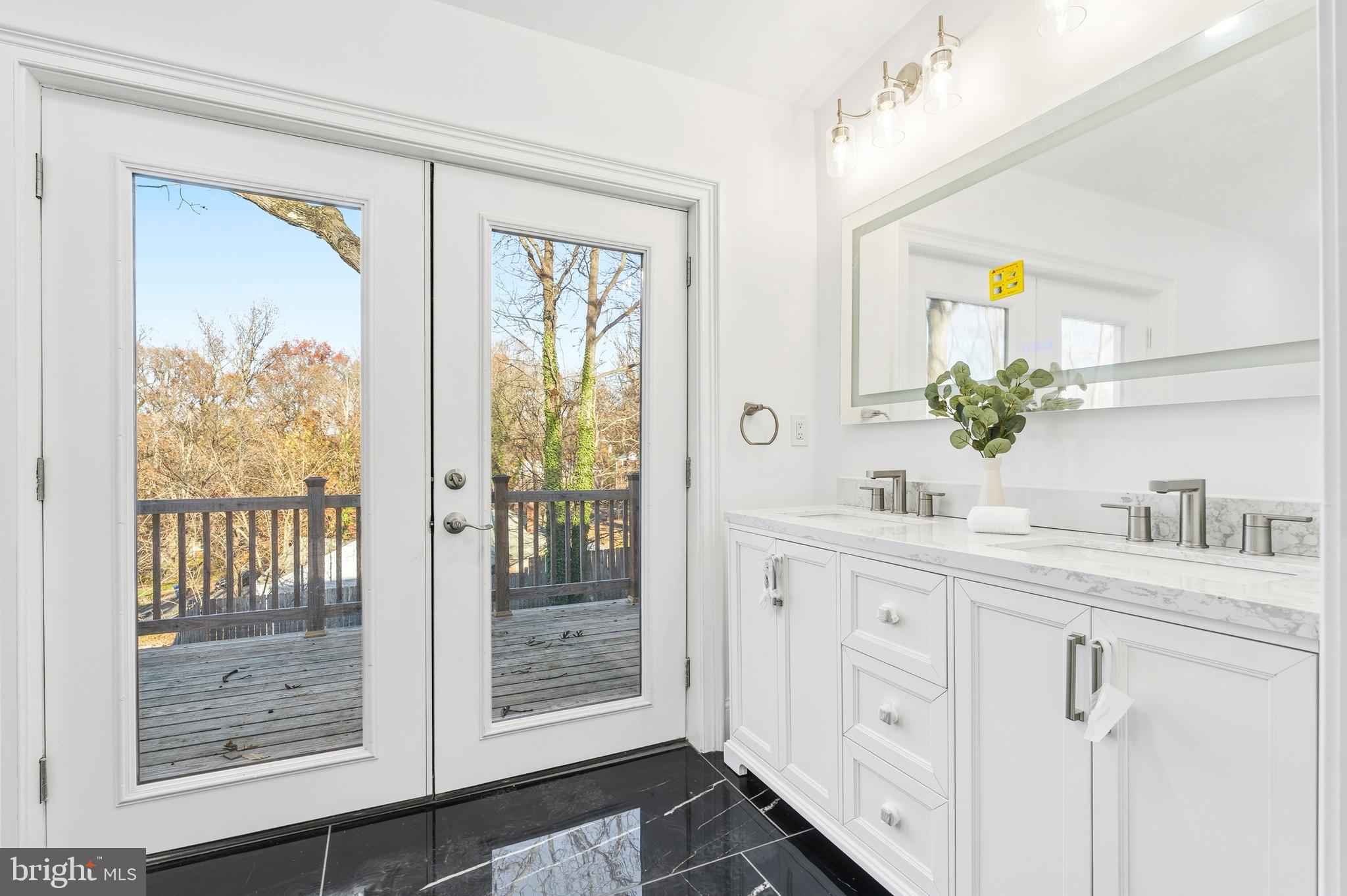 6218 Suitland Road Suitland, MD 20746 - Photo 23 of 52 a bathroom with a granite countertop sink a mirror a vanity and next to a window