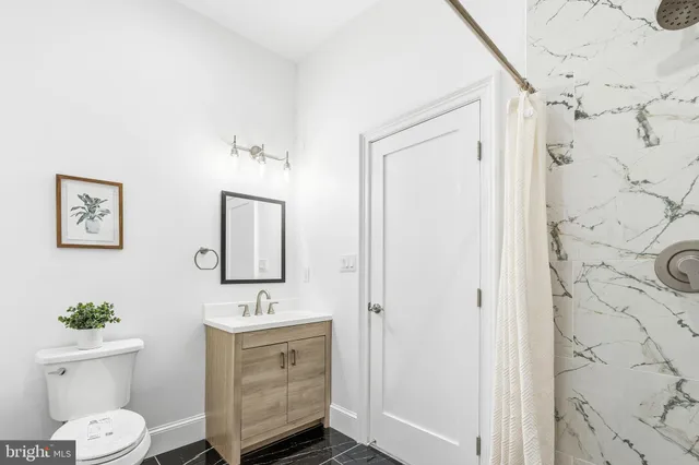 a bathroom with a sink a toilet and shower curtain