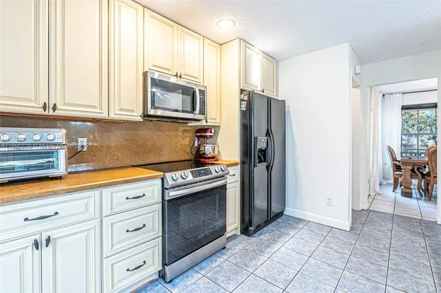 a kitchen with stainless steel appliances granite countertop a refrigerator and a stove top oven