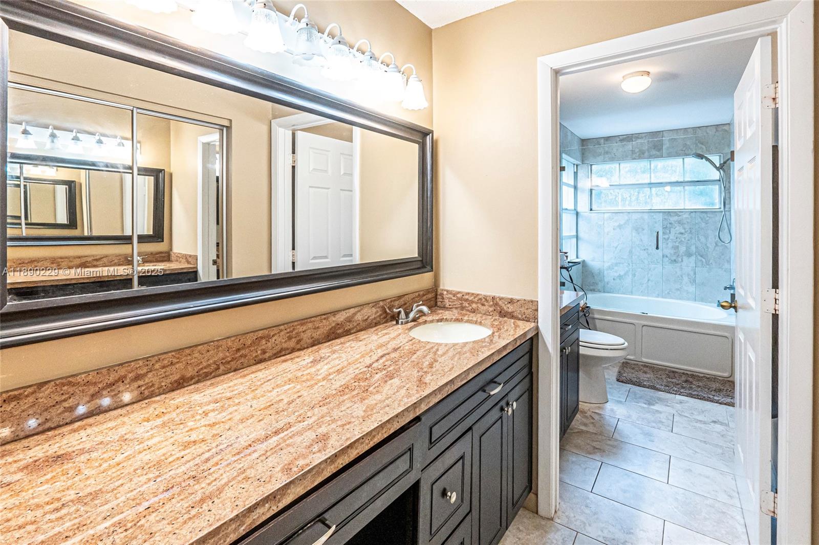 2913 Myrtle Oak Circle Davie, FL 33328 - Photo 26 of 35 a bathroom with a granite countertop sink and a bathtub