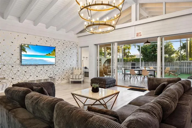 a living room with furniture a large window and a flat screen tv
