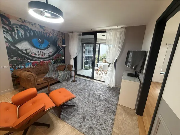 a living room with furniture a flat screen tv and a fireplace