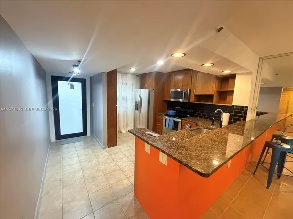 a kitchen with stainless steel appliances granite countertop a sink and a refrigerator