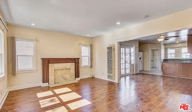 an empty room with wooden floor and a fireplace