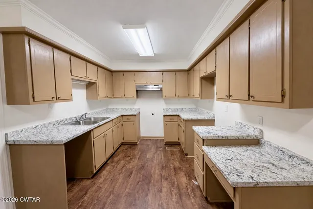 a kitchen with stainless steel appliances granite countertop wooden cabinets a stove top oven a sink and dishwasher