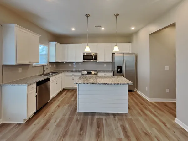 a kitchen with stainless steel appliances granite countertop a stove a sink and a refrigerator