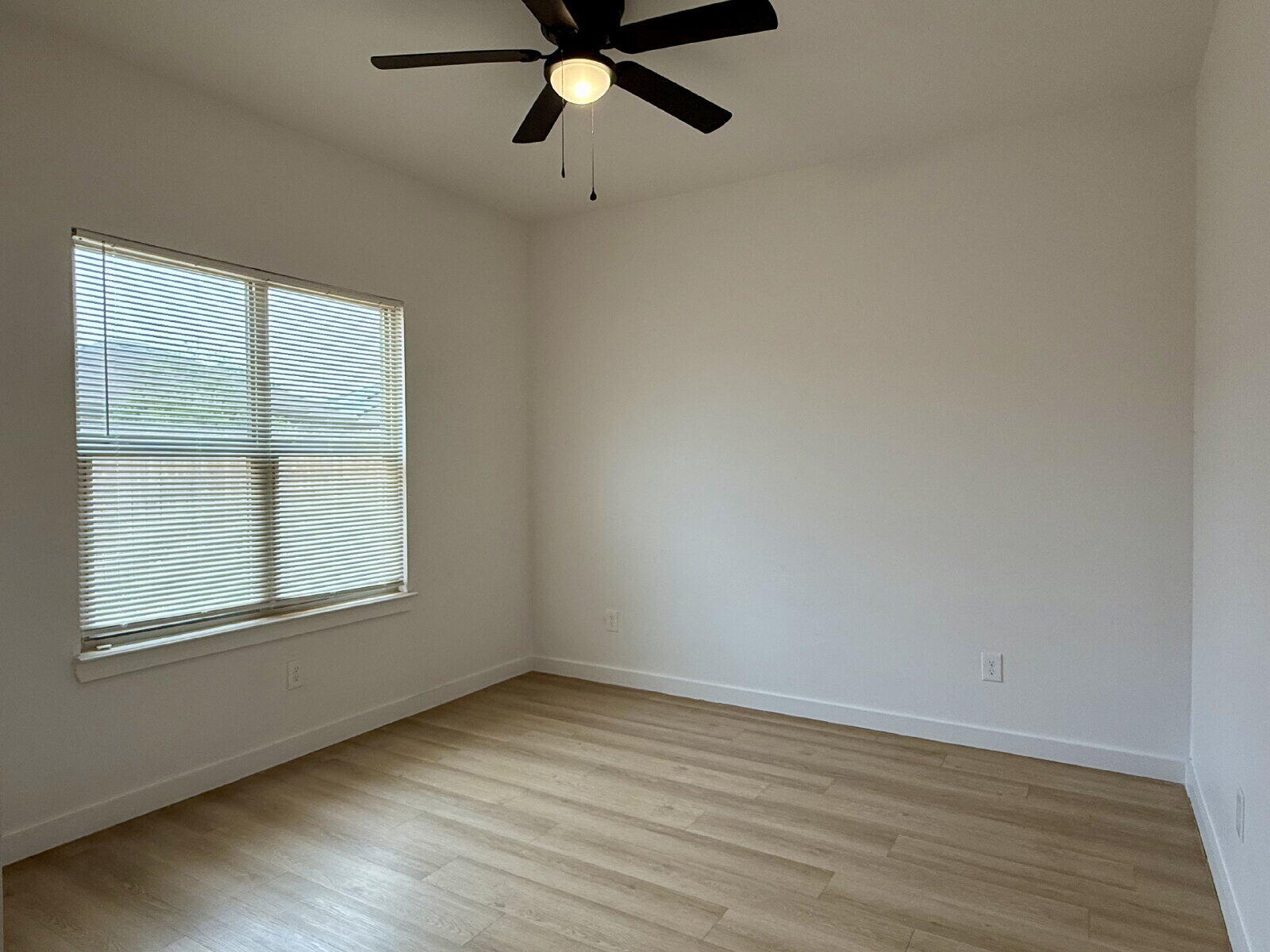 5703 Kemper Street, Unit 2 Lubbock, TX 79416 - Photo 14 of 26 wooden floor in an empty room with a window