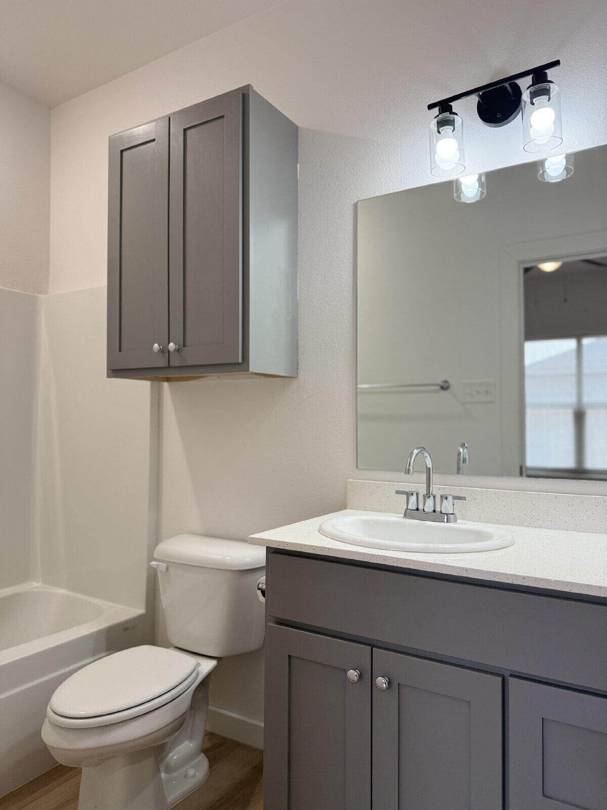 5703 Kemper Street, Unit 2 Lubbock, TX 79416 - Photo 16 of 26 a bathroom with a granite countertop sink a toilet and a mirror