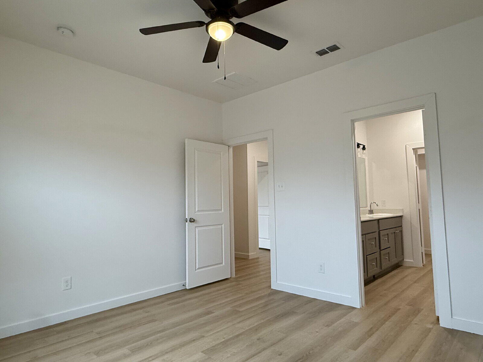5703 Kemper Street, Unit 2 Lubbock, TX 79416 - Photo 20 of 26 an empty room with wooden floor and ceiling fan