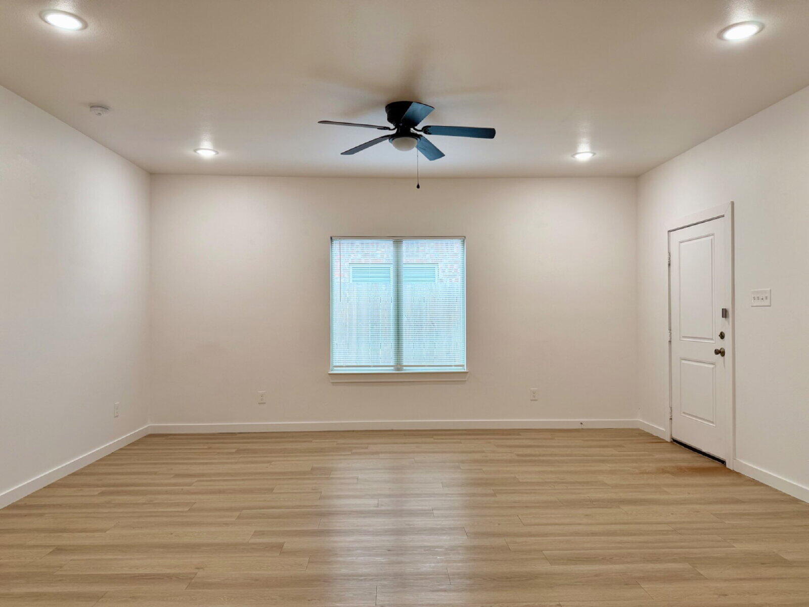 5703 Kemper Street, Unit 2 Lubbock, TX 79416 - Photo 3 of 26 wooden floor in an empty room with a window