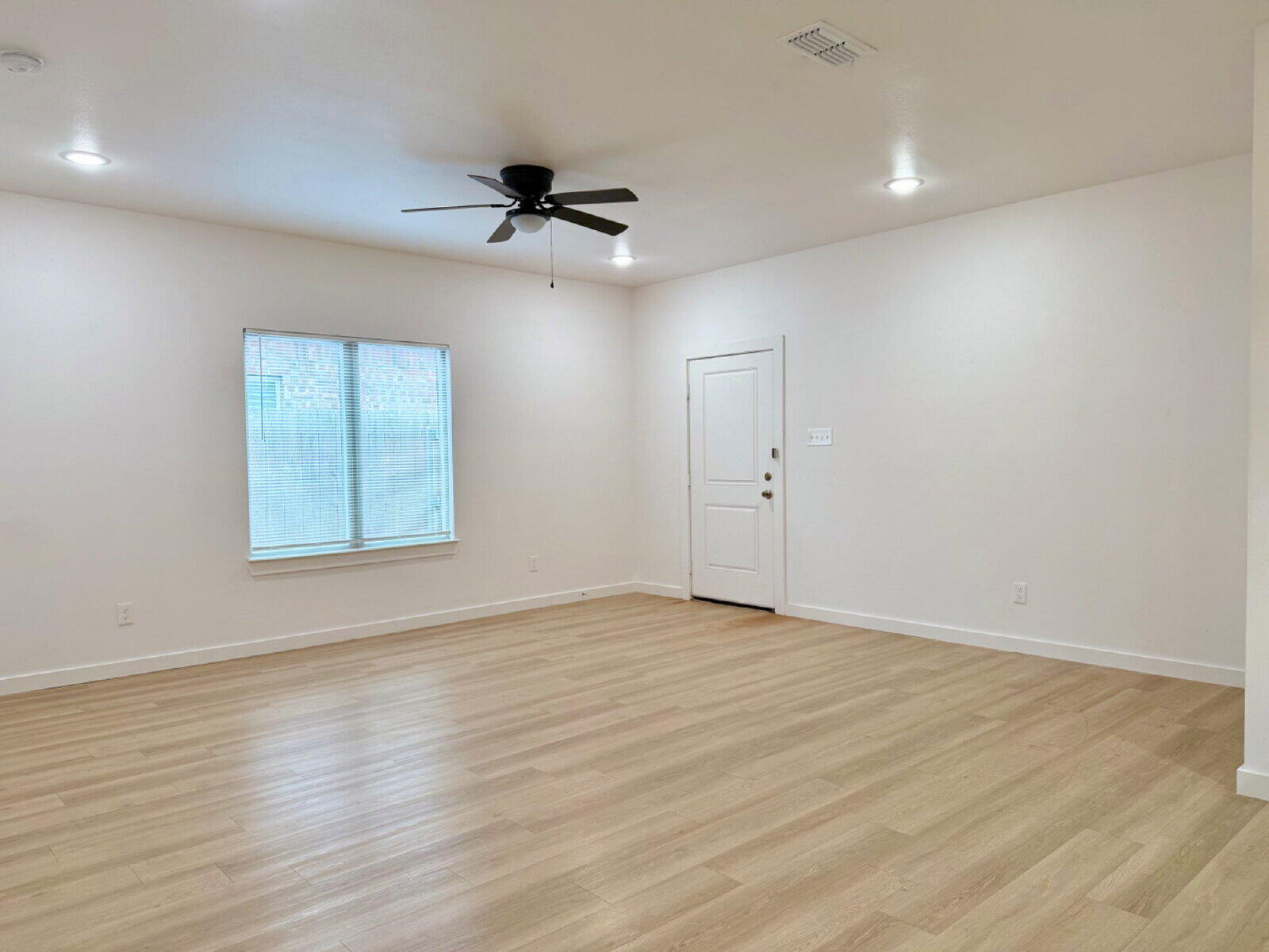 5703 Kemper Street, Unit 2 Lubbock, TX 79416 - Photo 4 of 26 wooden floor in an empty room with a window