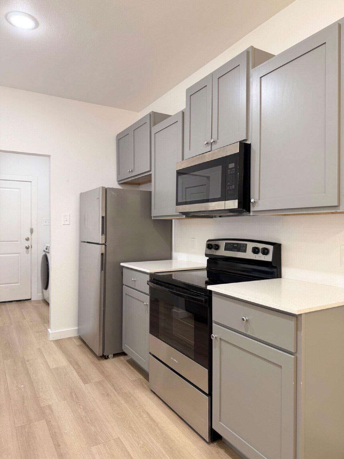 5703 Kemper Street, Unit 2 Lubbock, TX 79416 - Photo 9 of 26 a kitchen with stainless steel appliances white cabinets and wooden floor