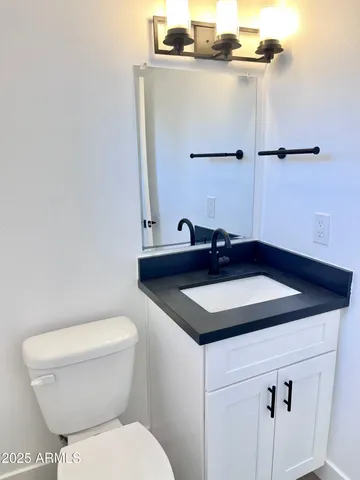 a bathroom with a sink a toilet and a mirror