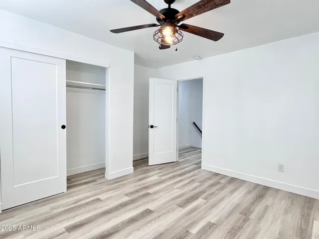 an empty room with a window and a fan