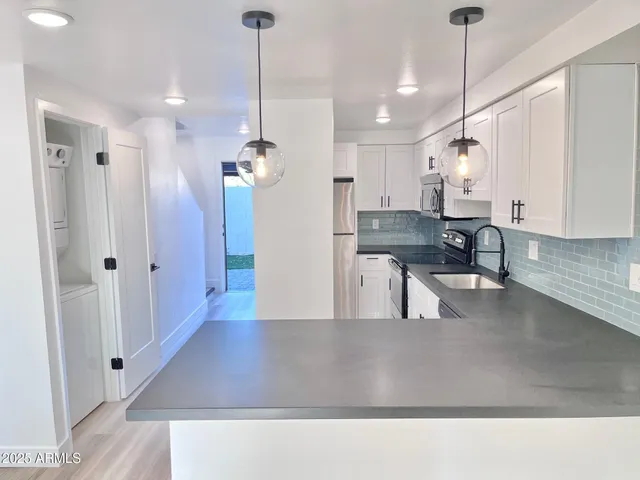 a living room with stainless steel appliances kitchen island furniture and a chandelier