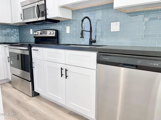 a kitchen with stainless steel appliances granite countertop a sink and cabinets