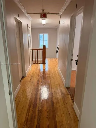 a view of a hallway with wooden floor and staircase