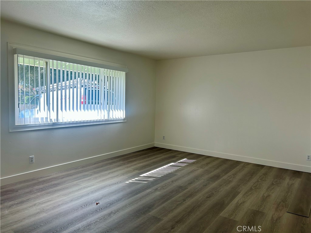 1007 Harrison Court Upland, CA 91786 - Photo 2 of 11 an empty room with wooden floor and windows
