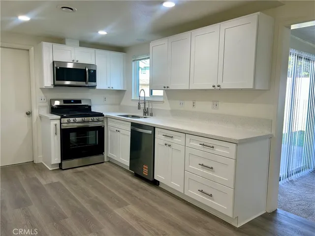 a kitchen with white cabinets stainless steel appliances and sink