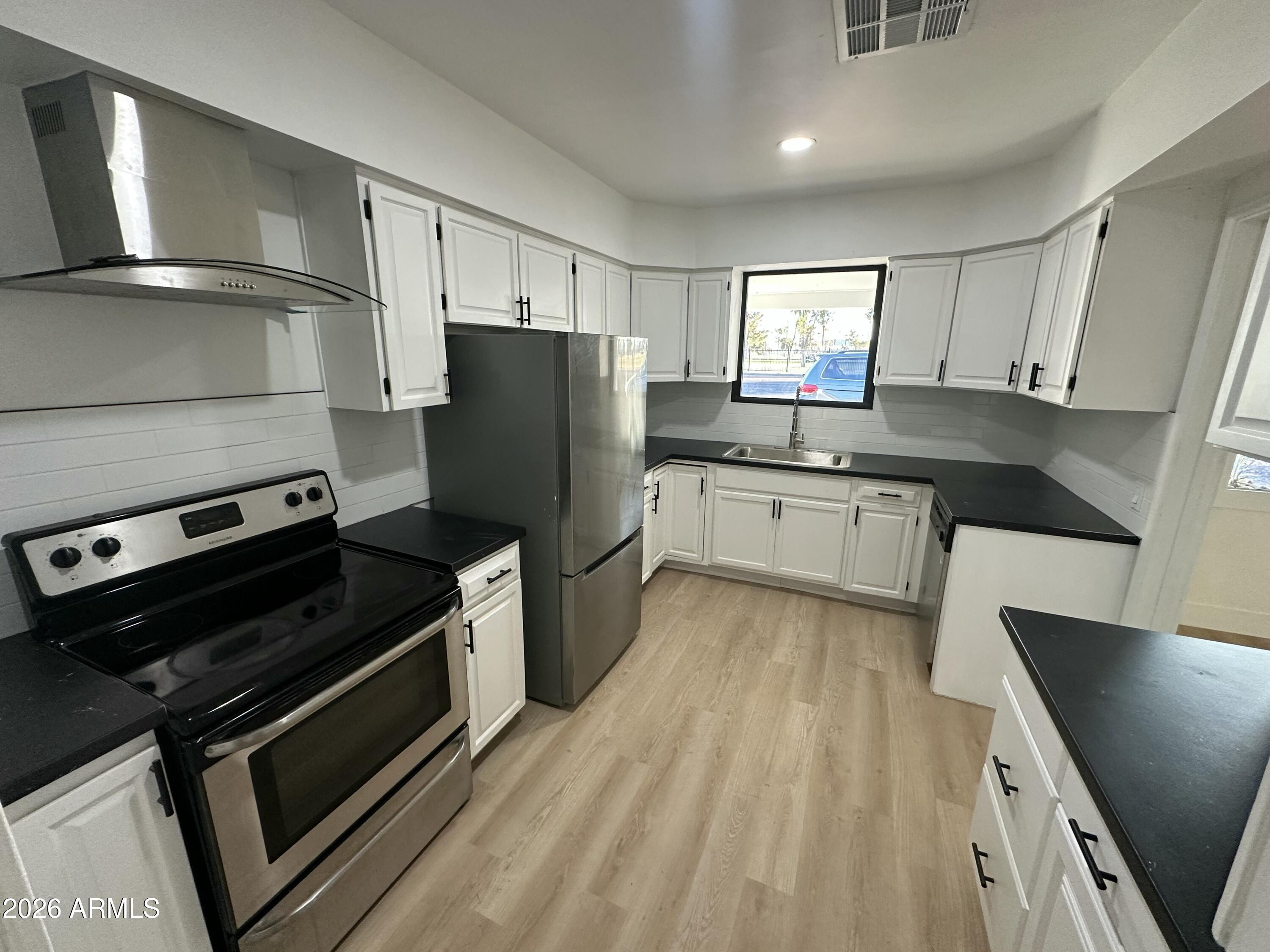 1730 West Thomas Road Phoenix, AZ 85015 - Photo 11 of 38 a kitchen with granite countertop a refrigerator stove and sink