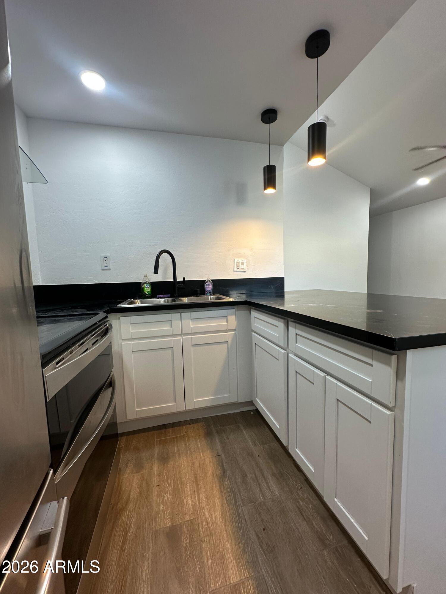 1730 West Thomas Road Phoenix, AZ 85015 - Photo 17 of 38 a kitchen with granite countertop white cabinets and white appliances