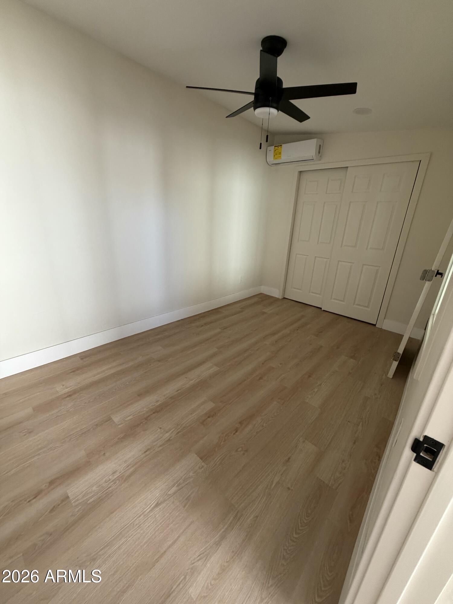 1730 West Thomas Road Phoenix, AZ 85015 - Photo 25 of 38 a view of empty room with wooden floor and fan
